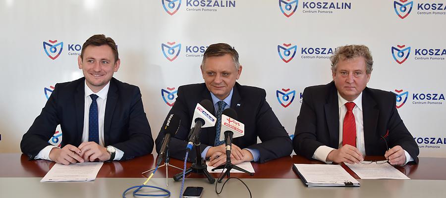  Fot. Urząd Miejski w Koszalinie. Przedstawiciele władz Koszalina – prezydent Piotr Jedliński (w środku) oraz wiceprezydent Przemysław Krzyżanowski (pierwszy z prawej) oraz wicemarszałek Tomasz Sobieraj (pierwszy z lewej) podpisują umowę.